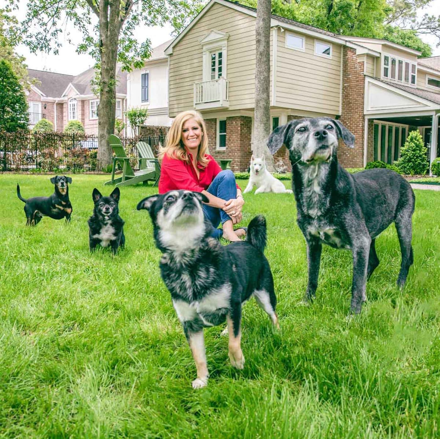 Leslie Harrelson outdoors with a group of dogs
